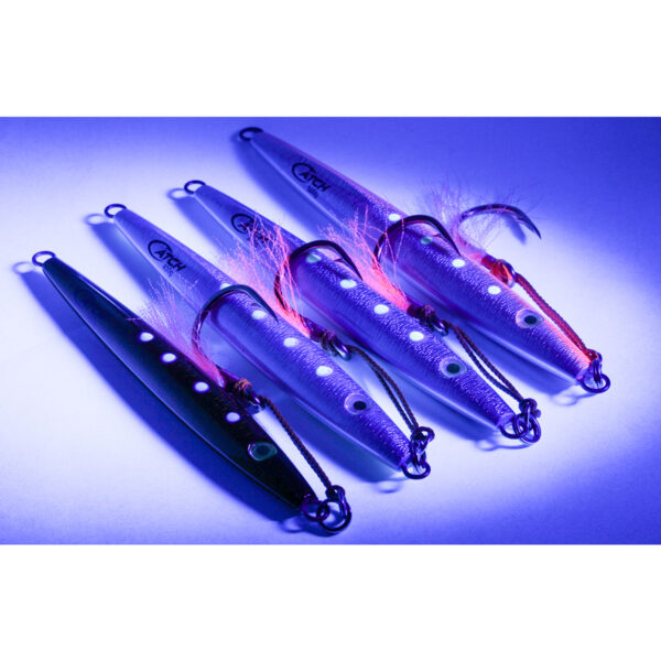 Under the captivating glow of purple light, four lures sit poised and ready for action. Three sparkle in silver, while one boasts a sleek black finish. Each is adorned with hooks and feather-like attire, meticulously crafted to entice that elusive trophy fish. But it's the Catch The Joker Longfall Jig that truly steals the spotlight—its design is not just unique but appears as if it holds an arcane secret, eager to unveil its irresistible charm and bag you your next big catch!.